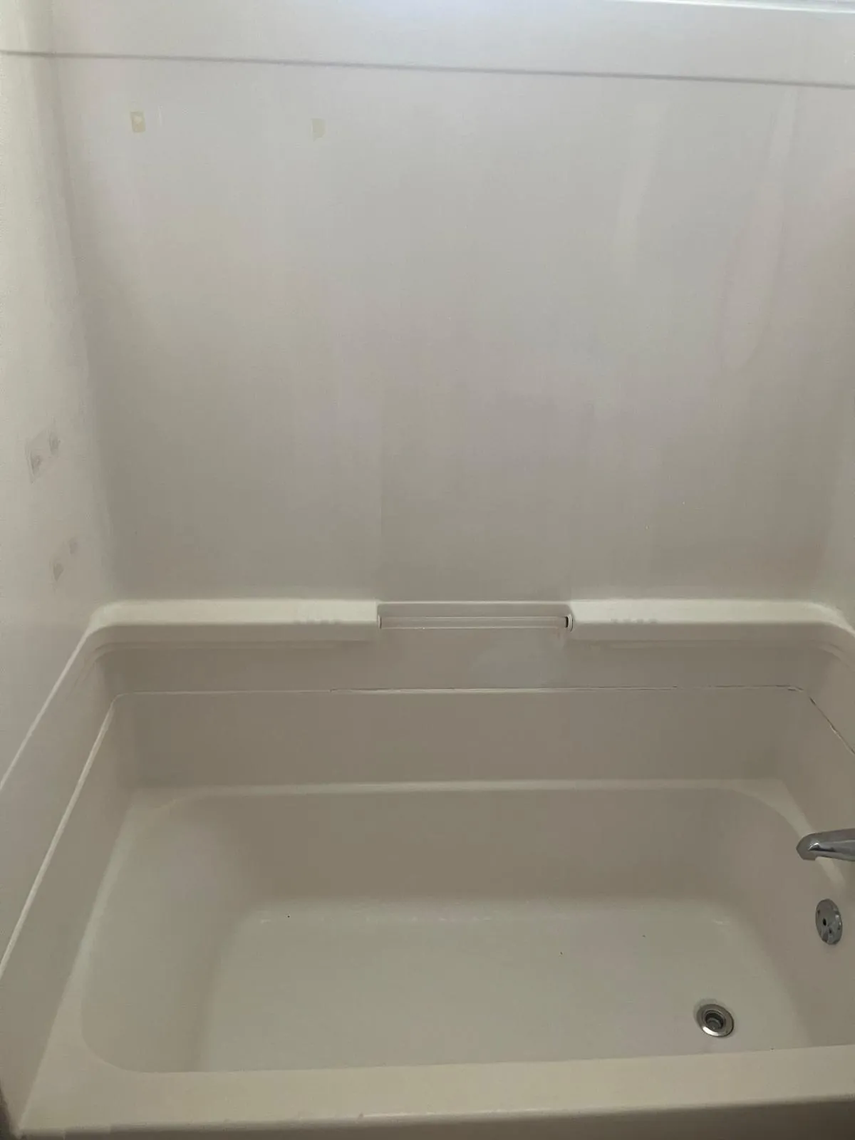 Clean bathtub and white shower surround after cleaning in Clinton, MA