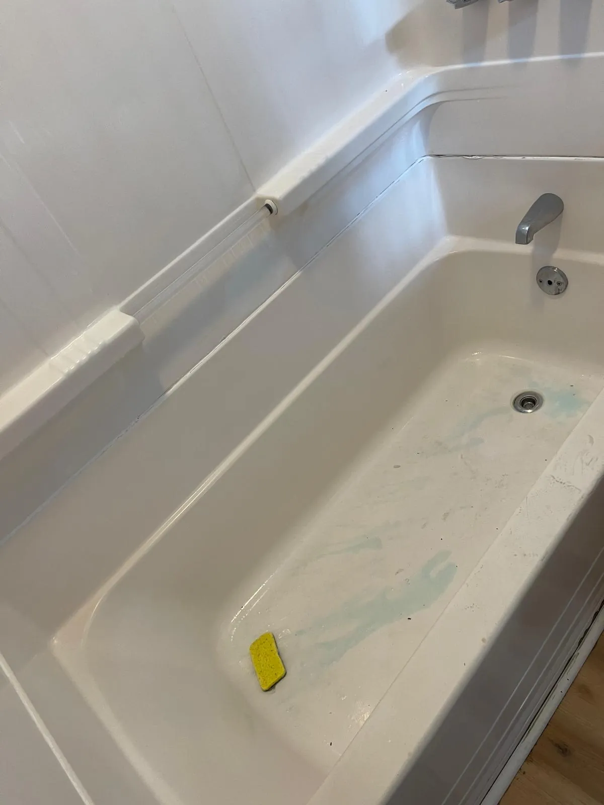Bathtub being scrubbed by hand with cleaning product during a Magic Cleaning visit in Clinton, MA