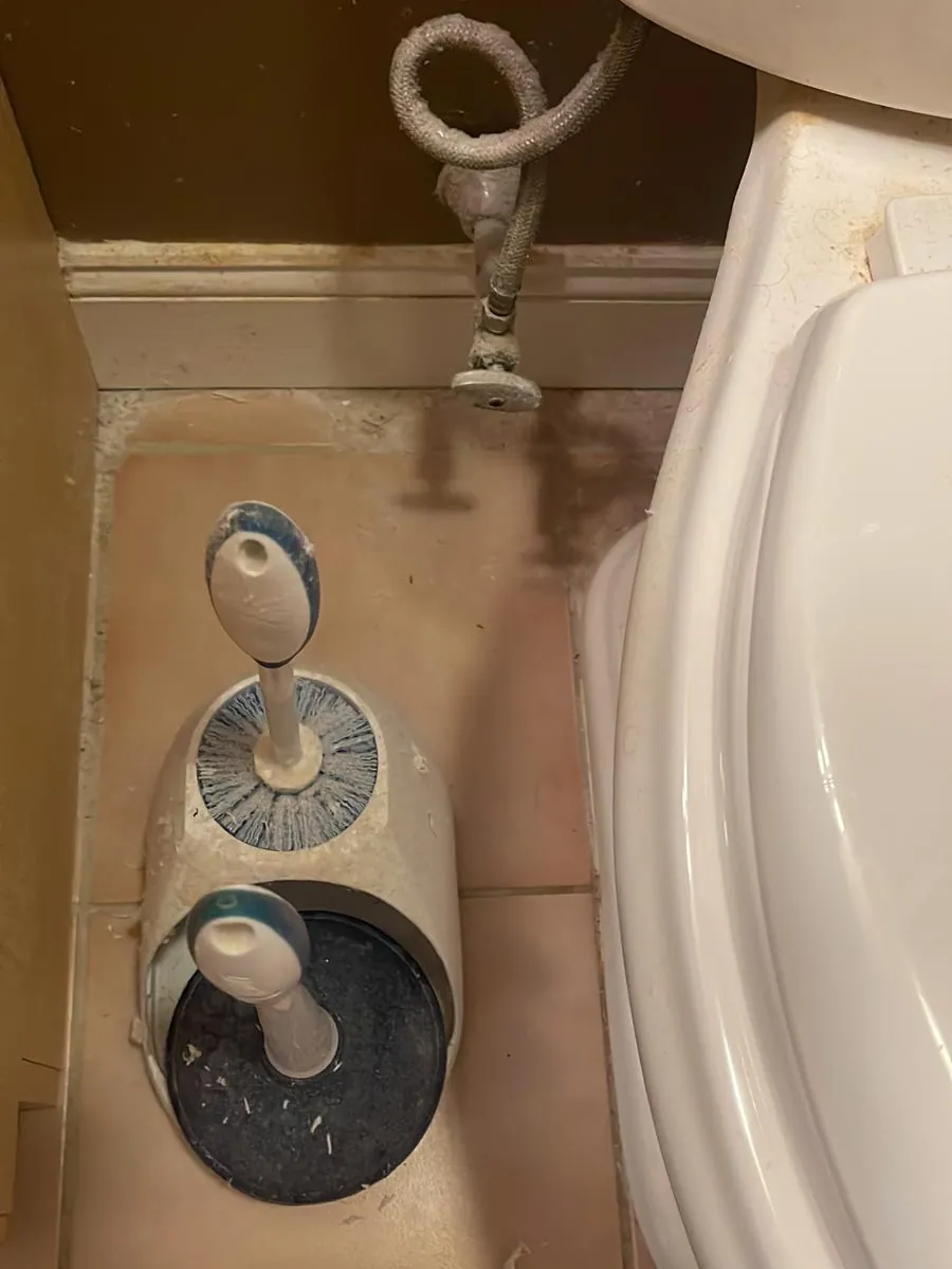 Bathroom floor tile and fixtures before cleaning in Clinton, MA, with dust and grime