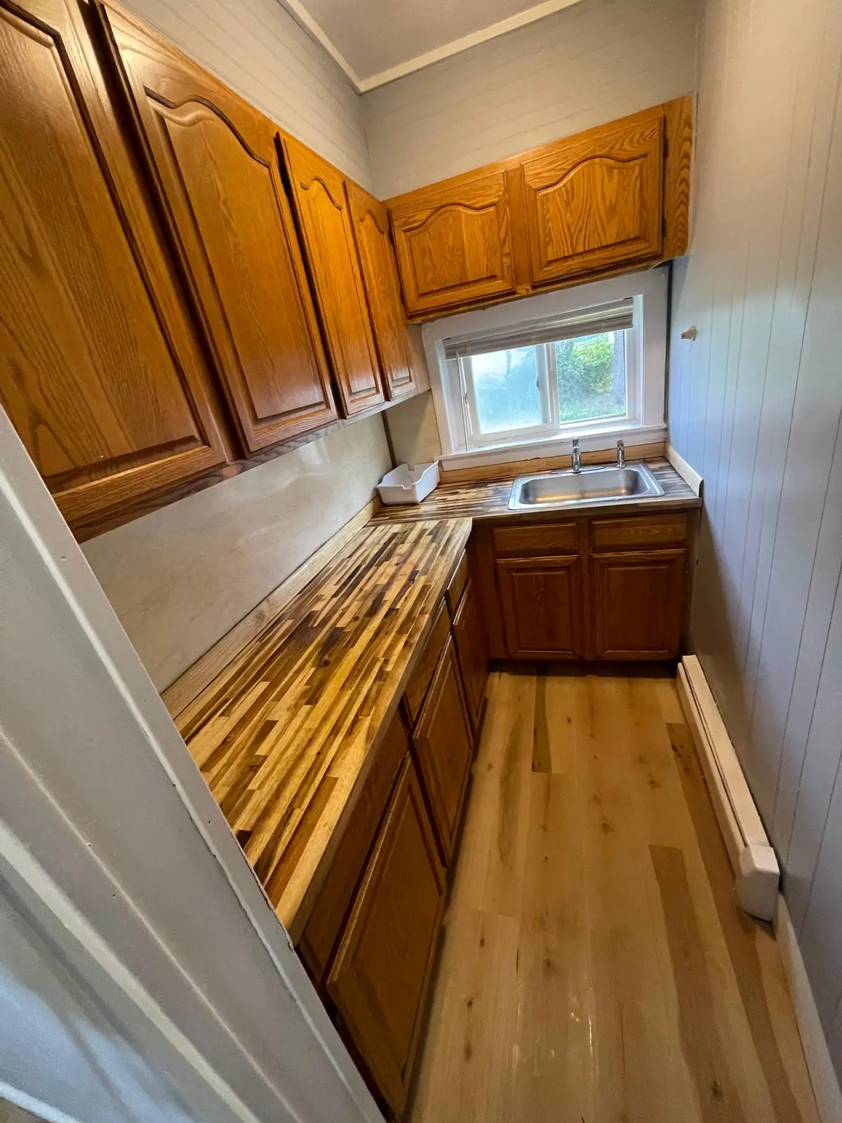Clean galley kitchen with wood cabinets after a deep cleaning in Clinton, MA